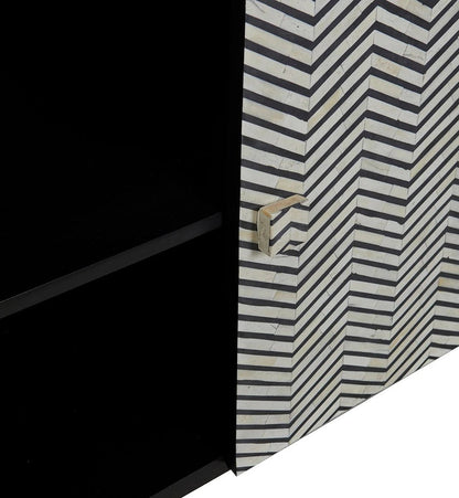 Macro detail of black and white chevron bone inlay pattern on cabinet door with handcrafted bone pull knob