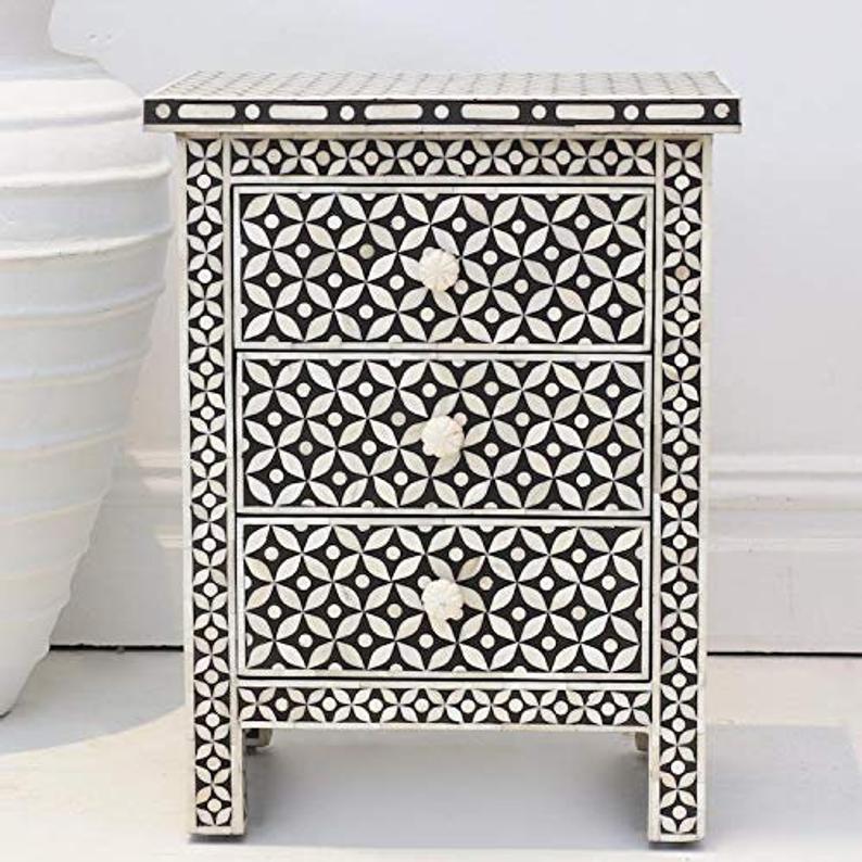 Black and white bone inlay three drawer nightstand with geometric star pattern and carved bone knobs on white background