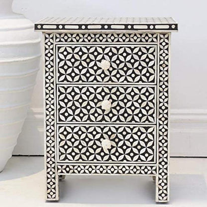 Black and white bone inlay three drawer nightstand with geometric star pattern and carved bone knobs on white background
