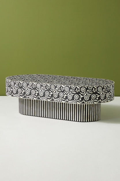 Black White Inlay Cocktail Table in black and white, shown from the side with its oval silhouette and striped floral surface.