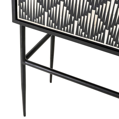 Lower section of a bone inlay bar cabinet showing the black powder-coated iron stand with tapered pointed legs, rectangular cross-brace stretcher, and the bottom edge of the black and white inlay door panels above