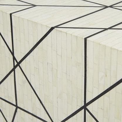 Macro detail of handcrafted ivory bone mosaic tile inlay with sharp black geometric lines on a luxury Indian artisan sideboard surface