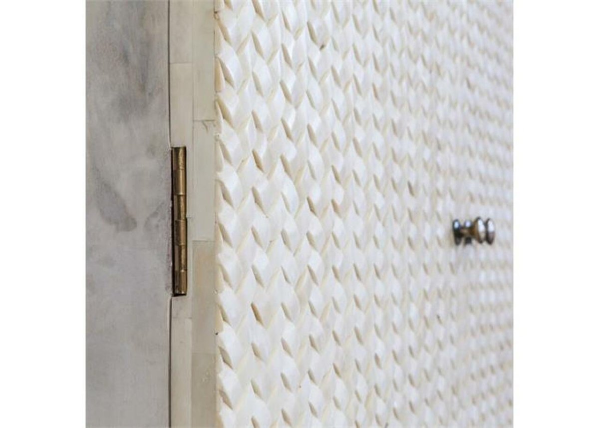 Detailed view of bone inlay herringbone textured cabinet door panel with brass hinge and silver knob hardware craftsmanship