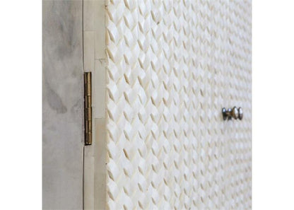 Detailed view of bone inlay herringbone textured cabinet door panel with brass hinge and silver knob hardware craftsmanship