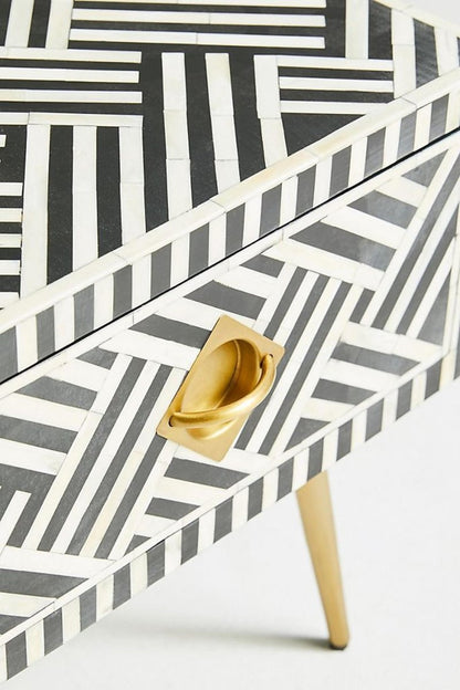 Black optical bone inlay table with the drawer closed, close-up front view of the pattern and brass pull