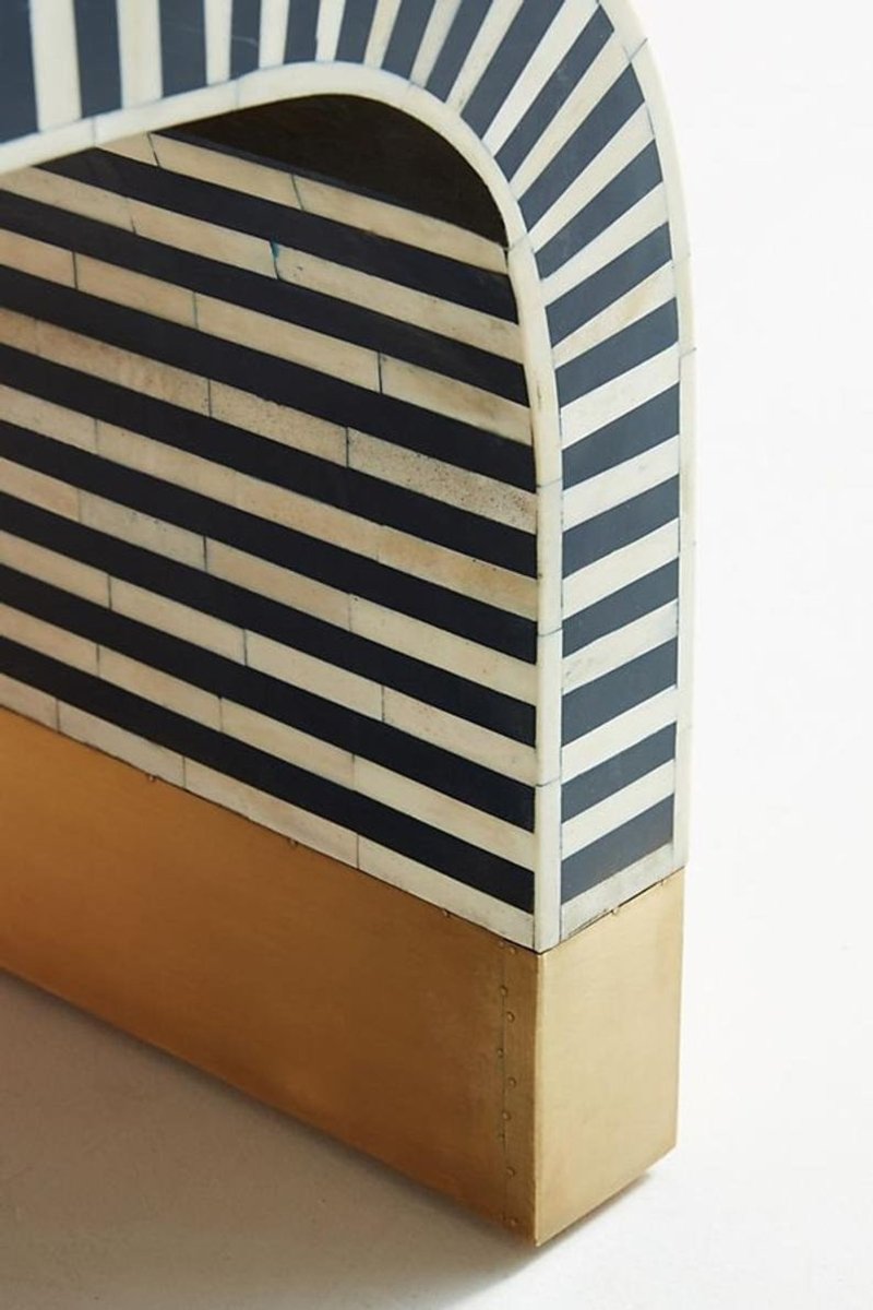 Back right close-up view of the handmade bone inlay waterfall coffee table, showing the navy and white striped side and underside, curved corner transition, pale inlay border, and gold-tone base with visible handcrafted surface variation.