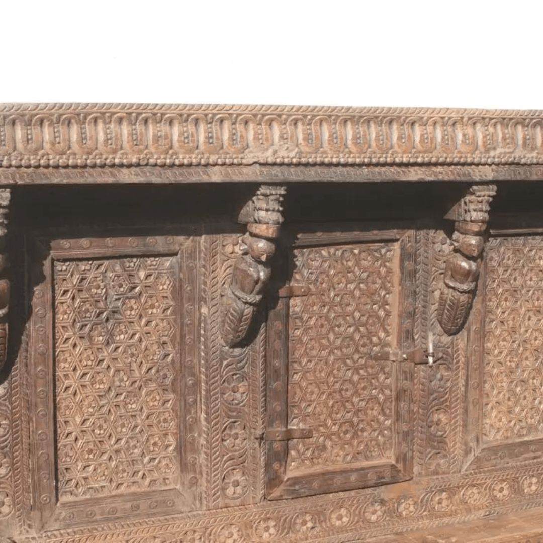 Floral carved wood dowry in a close-up of front detailing, showing rustic patterned panels and sculpted brackets.