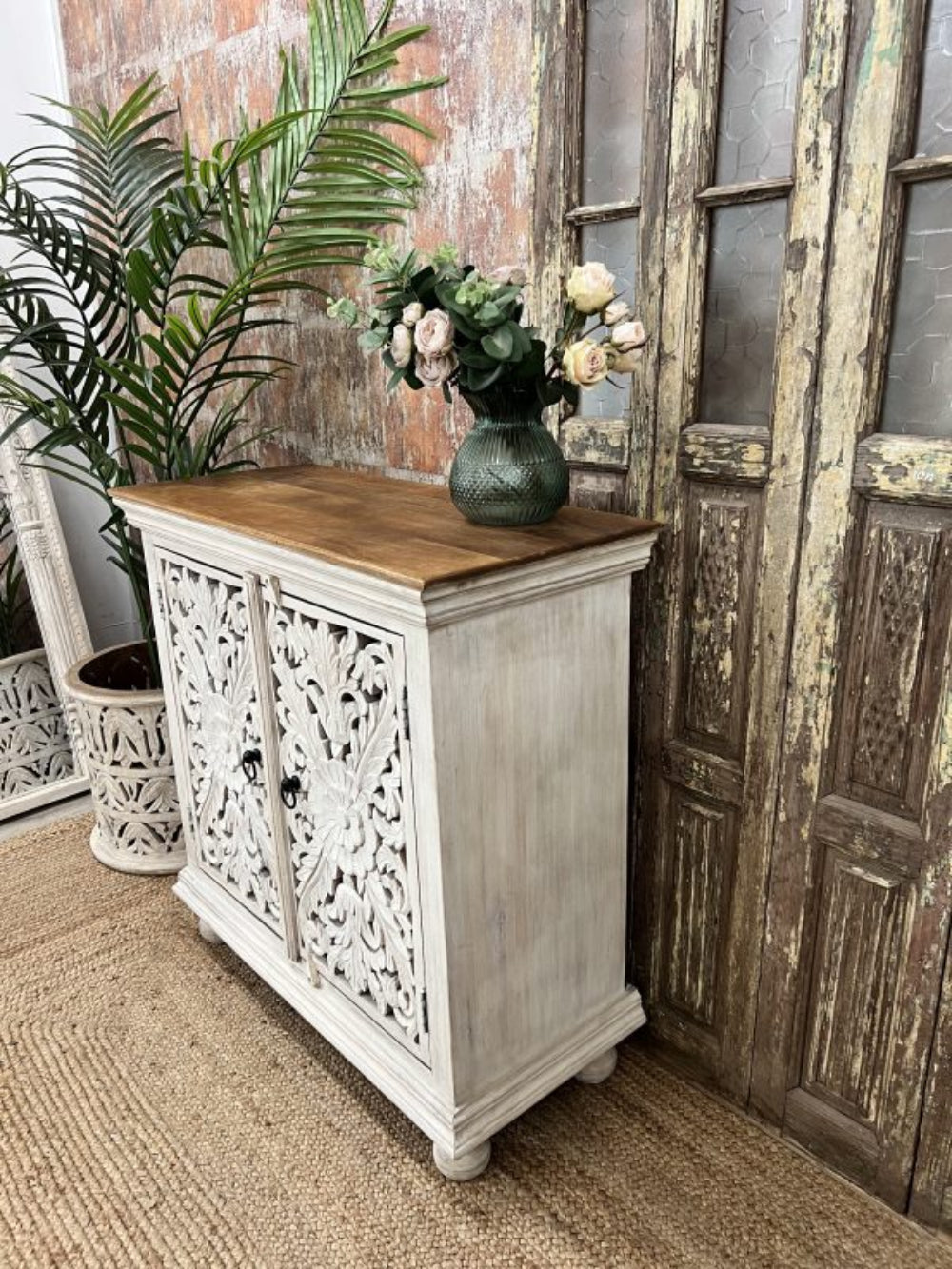 Floral two-door sideboard in rustic finished wood, side profile view showing the plain panel and projecting top.