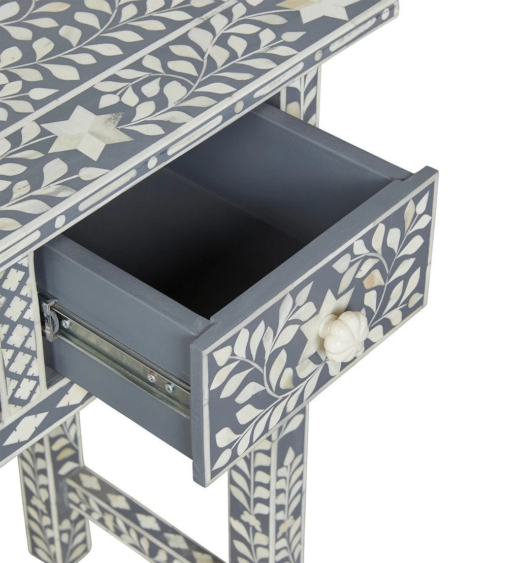 Open drawer of a grey bone inlay console table showing smooth interior, metal glide mechanism, white vine inlay on drawer front, and matching bone knob pull