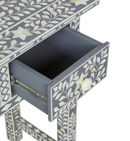 Open drawer of a grey bone inlay console table showing smooth interior, metal glide mechanism, white vine inlay on drawer front, and matching bone knob pull