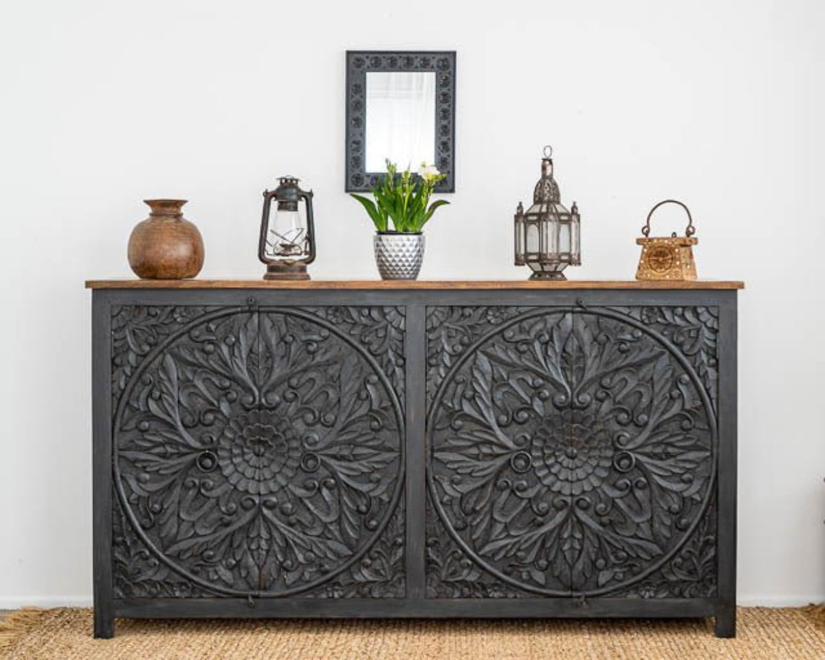 Hand Carved Large Buffet Table in black wood, shown in front view with floral mandala doors, lanterns and flowers.