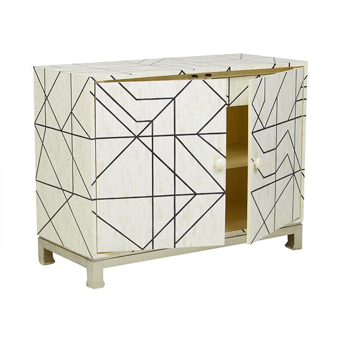Open two-door bone inlay sideboard showing interior gold-toned shelving, ivory mosaic body with bold black geometric line pattern and silver base