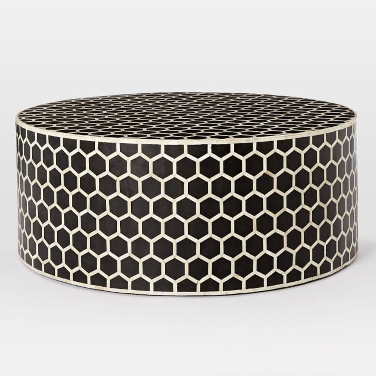 Front angle view of a handmade black bone inlay honeycomb round coffee table with a geometric hexagon pattern across its round top and drum base.