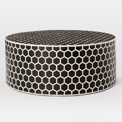 Front angle view of a handmade black bone inlay honeycomb round coffee table with a geometric hexagon pattern across its round top and drum base.