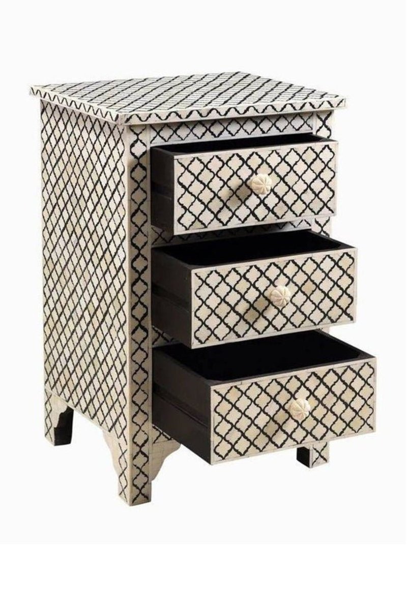 Open drawers of a handmade black and white bone inlay 3-drawer nightstand showing solid black interior, geometric trellis inlay and carved knobs
