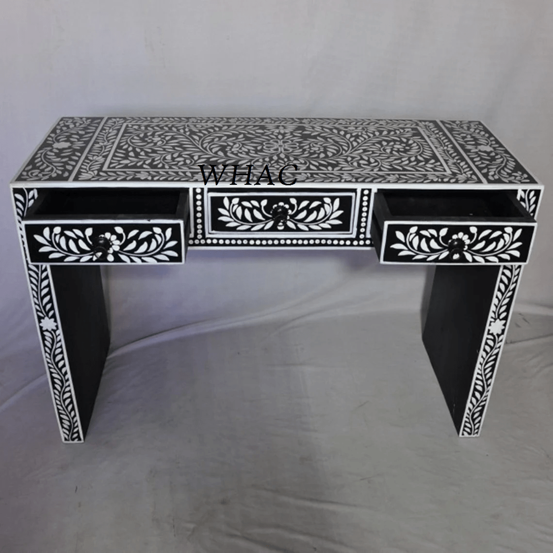 Handmade black bone inlay entryway table with three open drawers showing white floral leaf inlay pattern on drawer fronts, surface, and legs