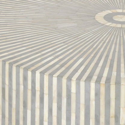 Side profile of handmade grey and ivory bone inlay round coffee table showing full cylindrical body with vertical stripe inlay and metal base, artisan luxury furniture for contemporary interiors