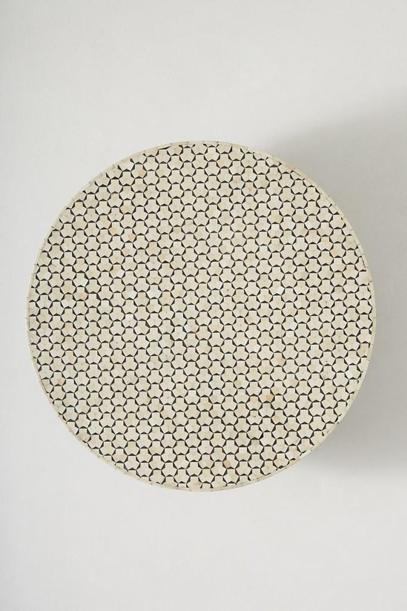 Top view of a round black and white bone inlay coffee table, showing the complete circular tabletop, repeating geometric hexagon star inlay, and contrasting handcrafted surface above its brass pedestal base.