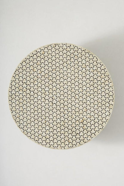 Top view of a round black and white bone inlay coffee table, showing the complete circular tabletop, repeating geometric hexagon star inlay, and contrasting handcrafted surface above its brass pedestal base.