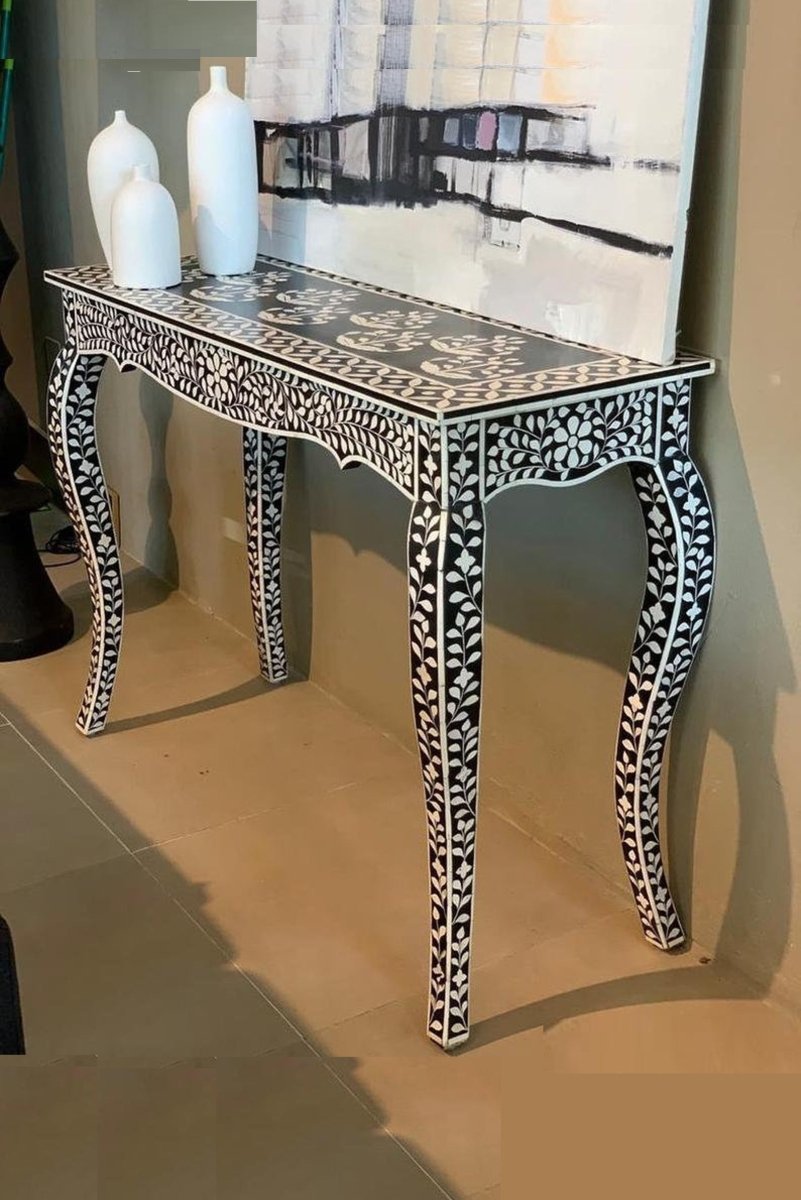 Black bone inlay French-leg hallway table in a side angle, showing the dark top, white floral inlay, shaped apron, curved cabriole legs, and slim profile with the decorative pattern continuing across the front.