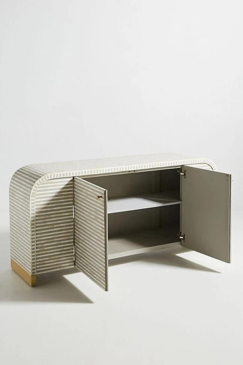 Left side profile of a handmade grey bone inlay buffet sideboard, showing the curved waterfall form, solid wood construction, and horizontal bone inlay pattern continuing across the cabinet surface. The full furniture piece remains visible.