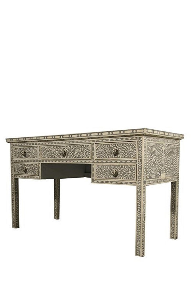 Three-quarter right-side view of a grey and ivory handmade bone inlay writing desk with drawers, showing the patterned front, decorated right side panel, rectangular top, and tapered legs. The isolated position highlights continuous floral inlay across the desk and side surfaces.