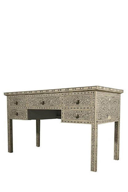Three-quarter right-side view of a grey and ivory handmade bone inlay writing desk with drawers, showing the patterned front, decorated right side panel, rectangular top, and tapered legs. The isolated position highlights continuous floral inlay across the desk and side surfaces.
