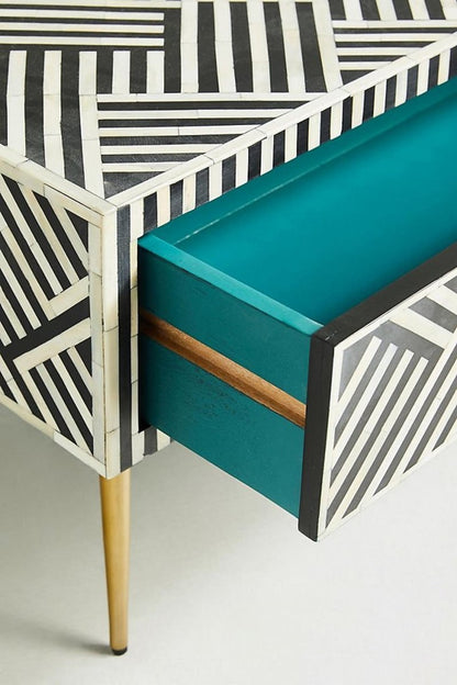 Black and white optical bone inlay pattern with brass drawer pull, close-up corner detail of the table front