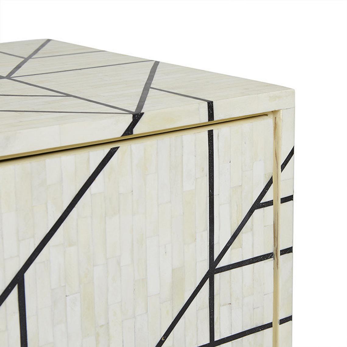 Upper corner detail of ivory bone inlay sideboard with bold black geometric lines, gold brass-toned trim edge and handcrafted mosaic tile craftsmanship