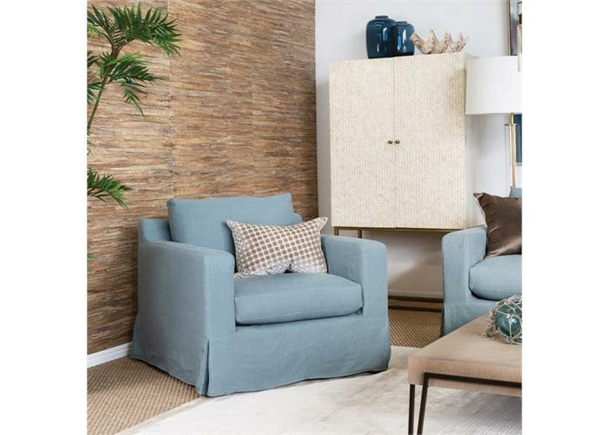 Ivory bone inlay herringbone bar cabinet with brass stand styled in a coastal living room setting beside a blue armchair and decor