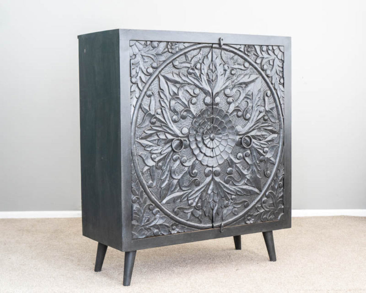 Mandala Two Door Credenza in charcoal wood, shown in angled front view revealing its plain left side and tapered legs.
