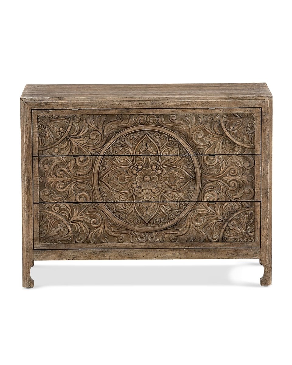 A 3-drawer solid wood dresser featuring a large, intricate hand-carved floral mandala pattern in a weathered natural wood finish.