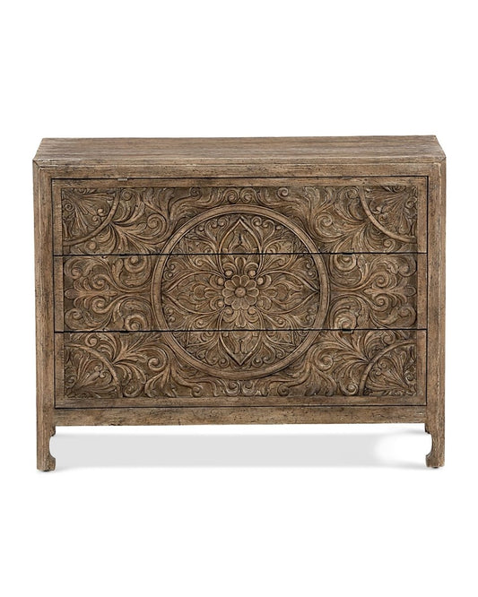 A 3-drawer solid wood dresser featuring a large, intricate hand-carved floral mandala pattern in a weathered natural wood finish.
