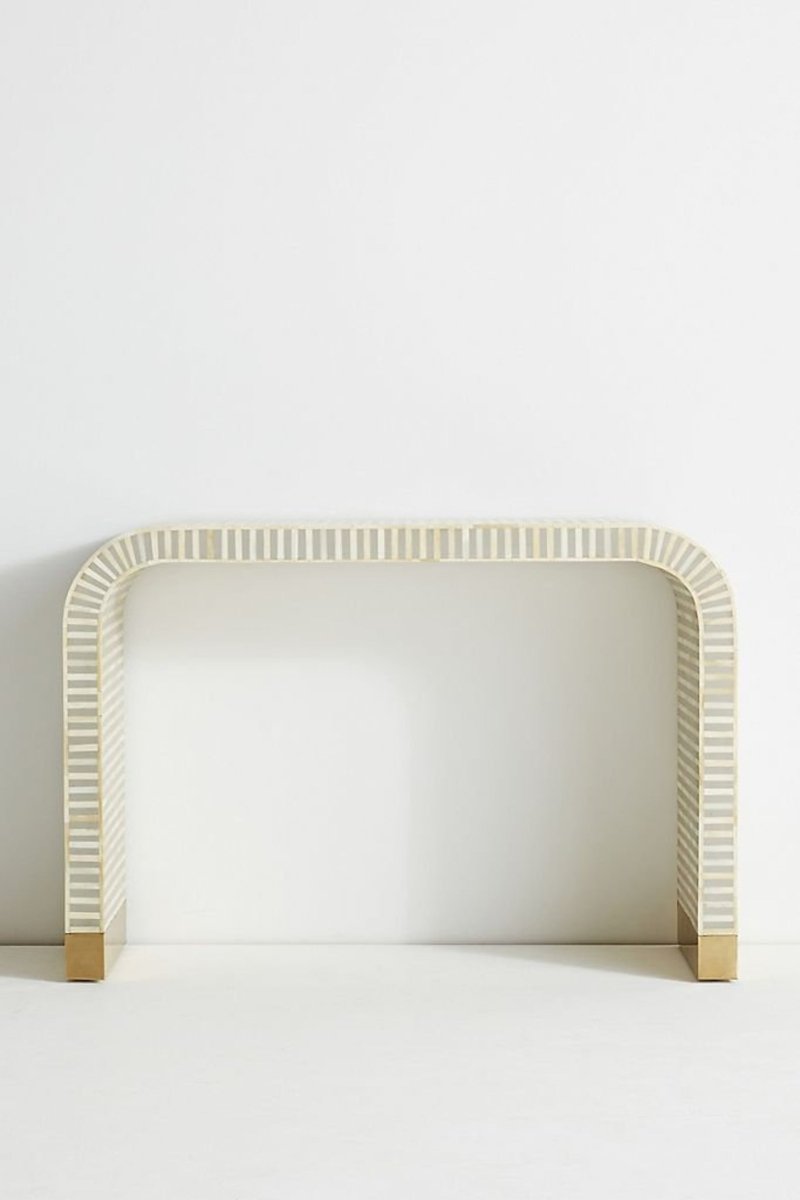 Front angle of a gray and white striped bone inlay waterfall console table, showing the rounded continuous silhouette, linear inlay pattern across the top and front, and brushed gold brass-capped feet. The full console table is presented against a plain light background.