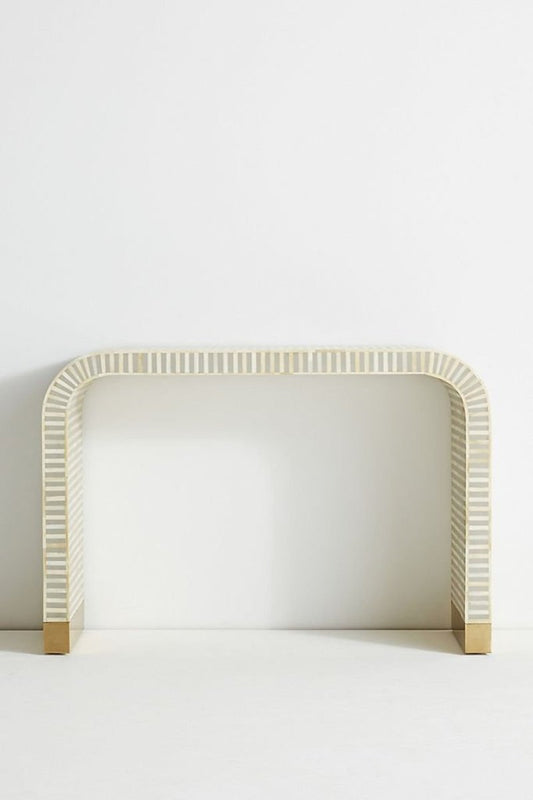 Front angle of a gray and white striped bone inlay waterfall console table, showing the rounded continuous silhouette, linear inlay pattern across the top and front, and brushed gold brass-capped feet. The full console table is presented against a plain light background.