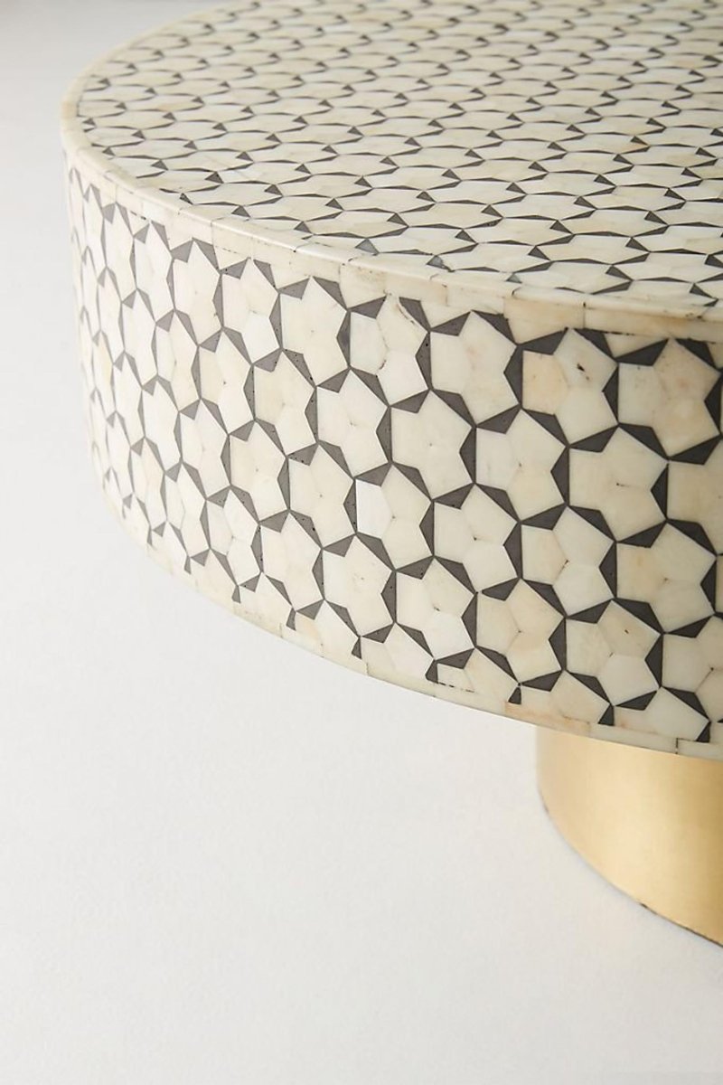 Close-up view of the round black and white bone inlay coffee table, showing the hand-placed geometric hexagon star inlay across the tabletop and the detailed contrast between the bone surface and charcoal pattern.