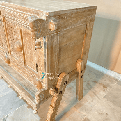 Natural paneled storage cabinet in solid wood, side profile view showing the right panel, leg braces and carved post.
Natural paneled storage cabinet in solid wood, side profile view showing the right panel, leg braces and carved post.