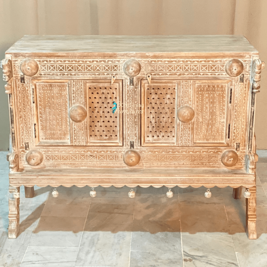 Natural wood carved buffet, front view showing two patterned doors, round wooden accents and hanging ornaments.