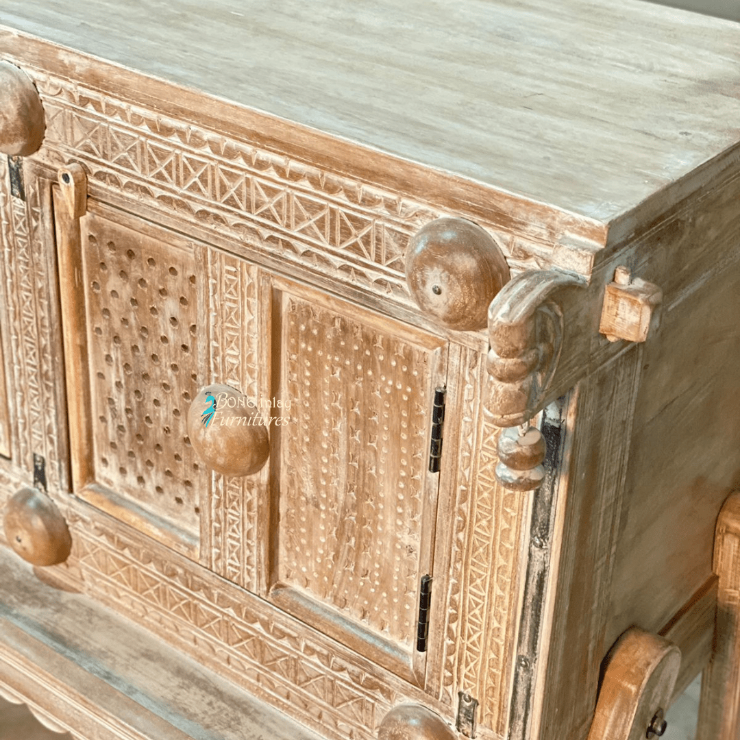 Natural wood dowry chest, corner detail view showing the right scroll ornament, patterned door and exposed hinges.