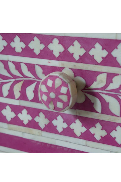 Close up of Pink floral bone inlay bedside cabinet with three drawers, a vine and medallion pattern, and matching knobs.