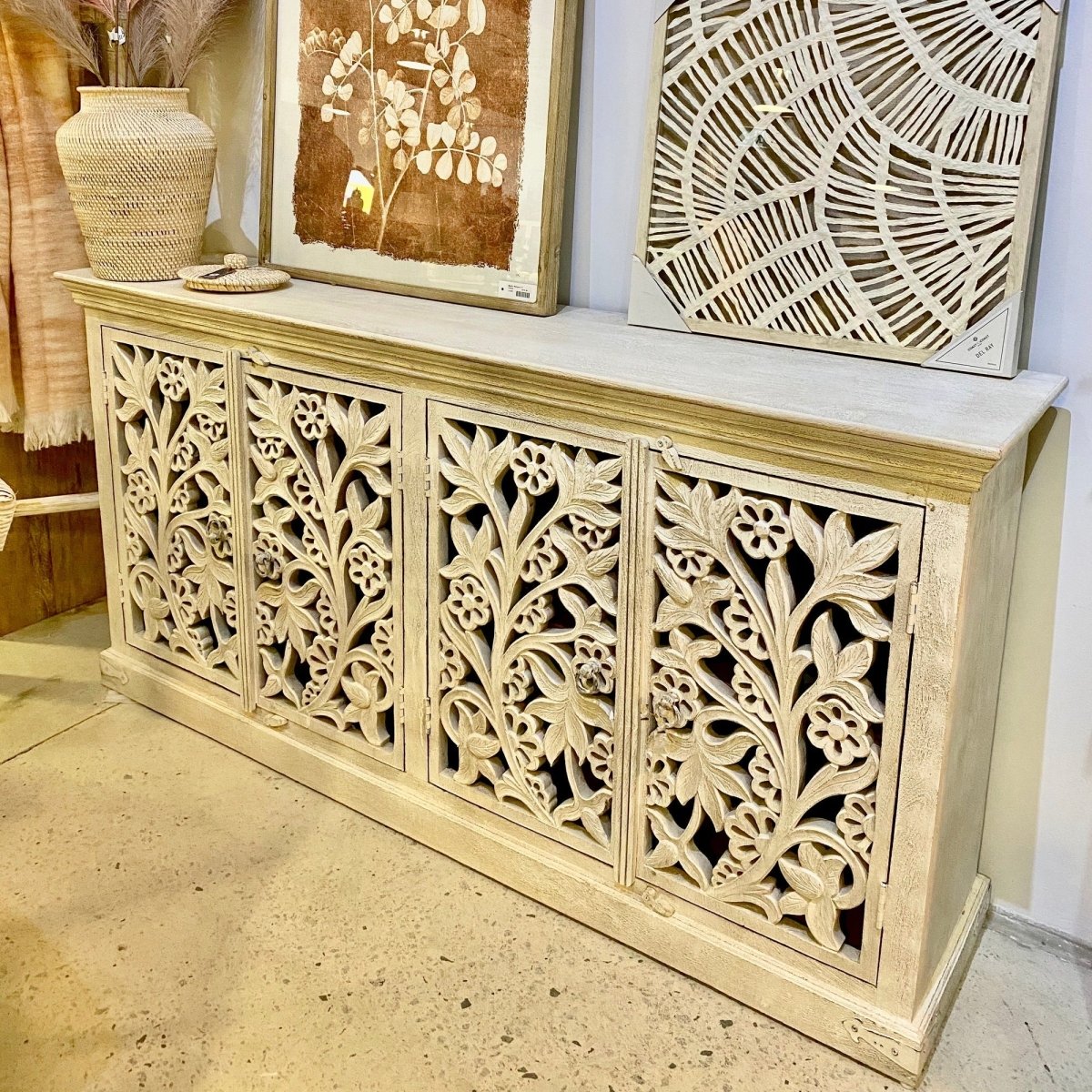 Rustic floral storage cabinet in solid wood, front view at an angle showing carved doors and the right side.