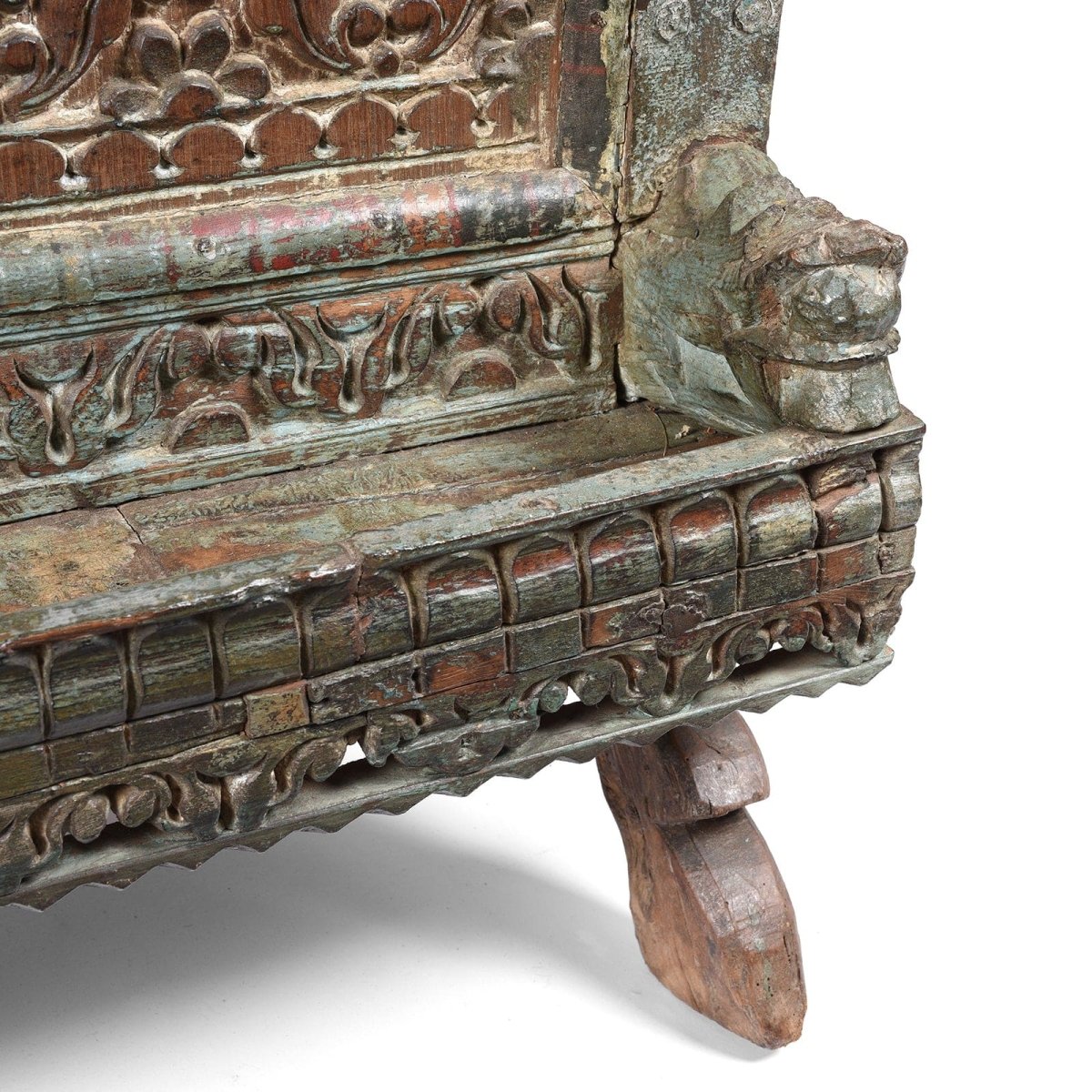 Rustic wood dowry chest, base detail view showing a carved animal figure, layered decorative rails and an angled foot.