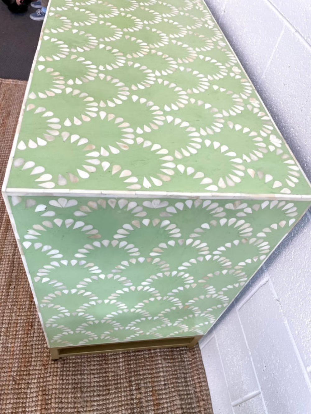 Sage green bone inlay cabinet with scalloped fish-scale pattern, two doors, and brass cylindrical knobs on a jute rug