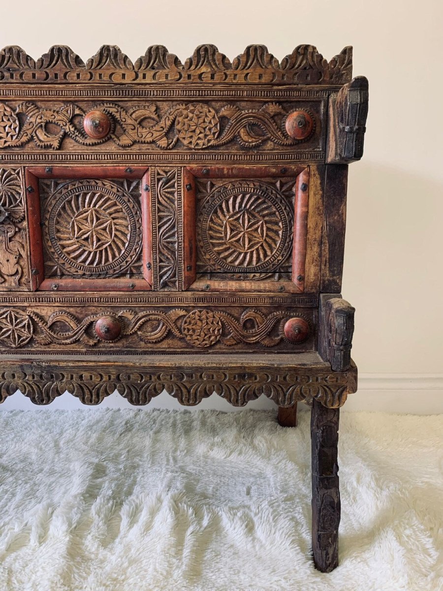 Scalloped wooden hope chest in natural wood, front view cropped to the right rosette panels and decorative border.