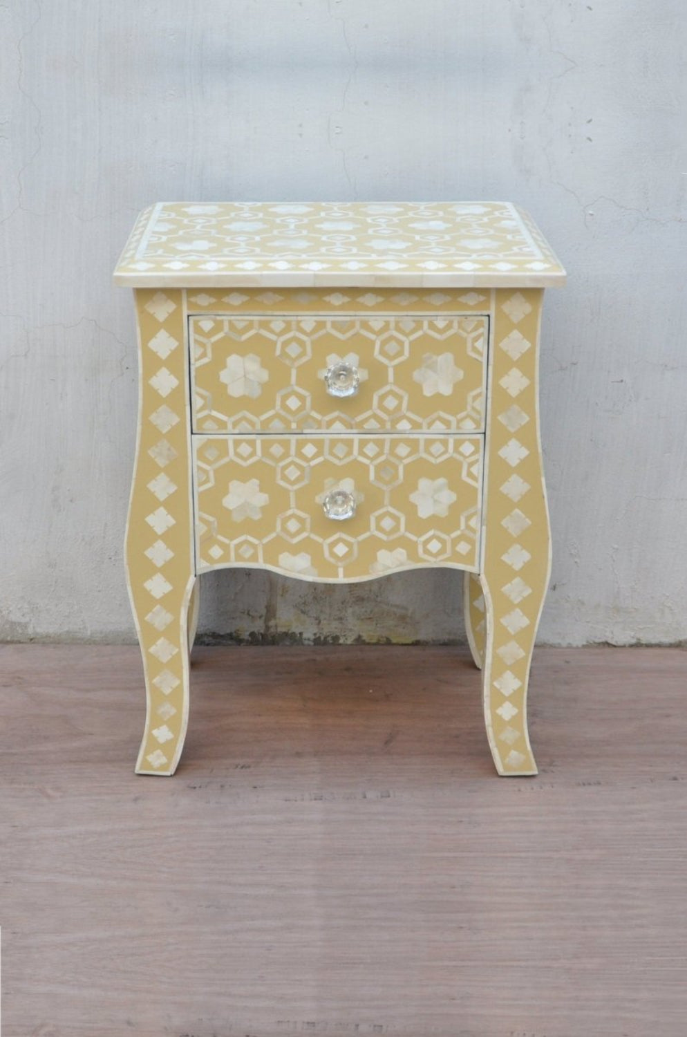 Geometric Star Bedside Table in mustard yellow bone inlay shown in three-quarter view with scalloped trim and curved legs