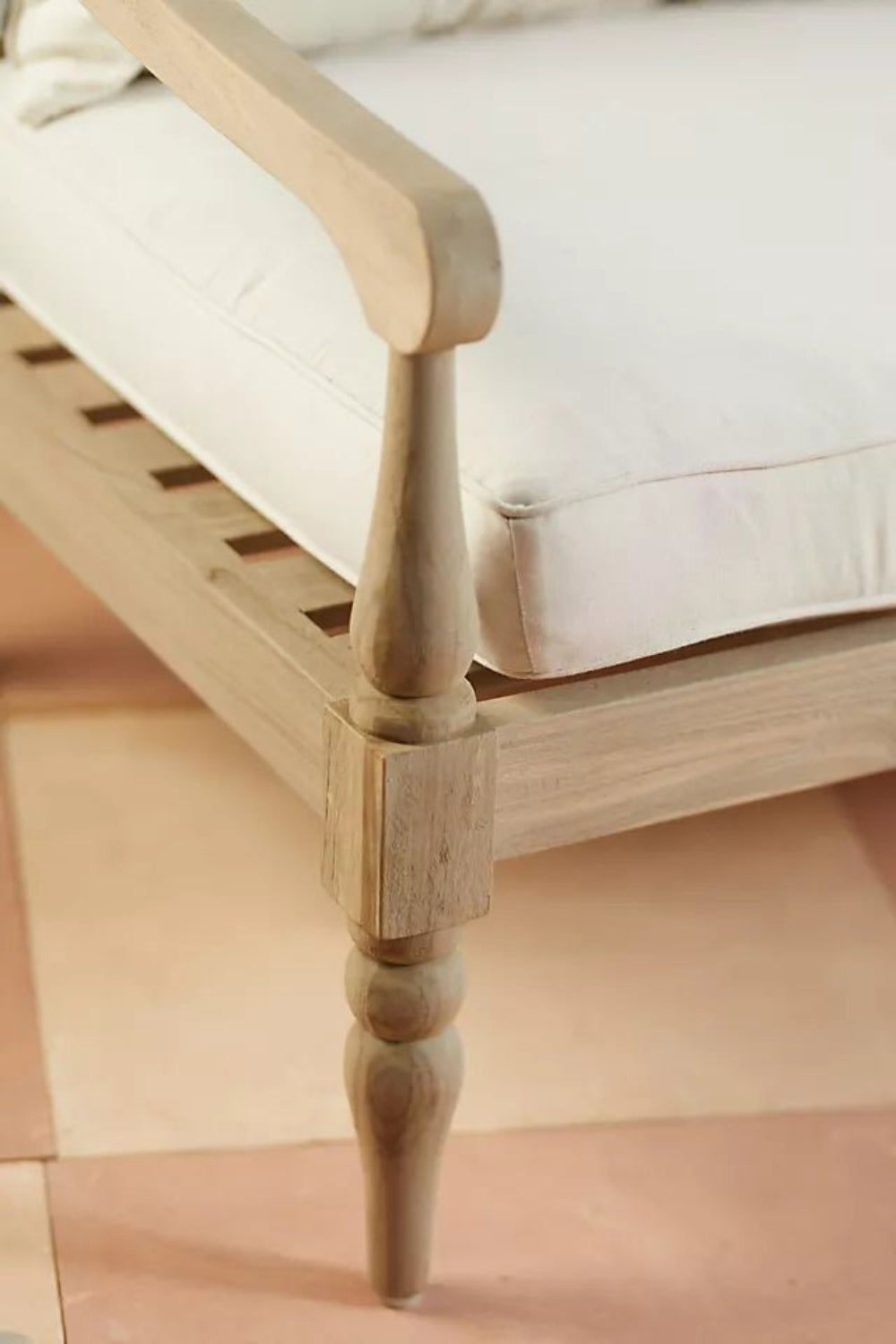 Turned leg couch in solid wood, close-up of leg showing its tapered foot, rounded carving and seat frame joint.