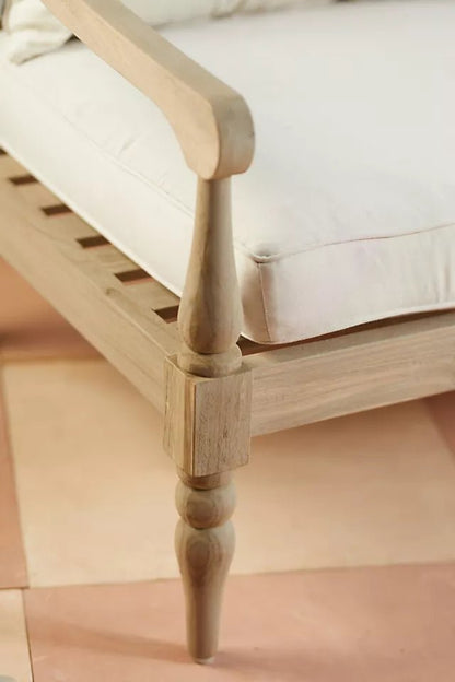 Turned leg couch in solid wood, close-up of leg showing its tapered foot, rounded carving and seat frame joint.