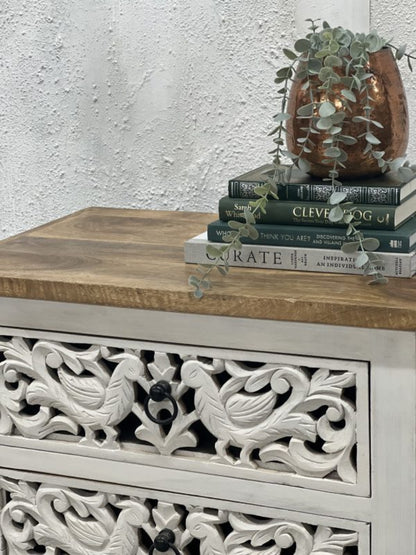 Wood top peacock chest in rustic mango wood, edge detail view showing the brown top above carved drawer fronts.