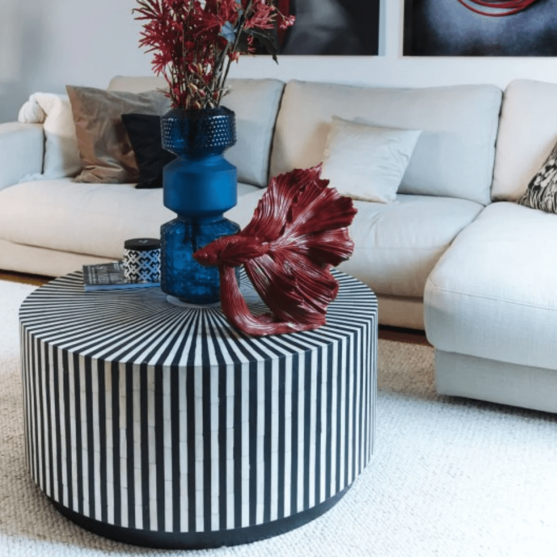 Black and white bone inlay coffee table with vertical stripes and round base shown in a front angle product view.