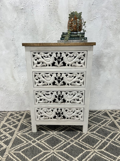 A 4-drawer accent chest made of solid wood with intricate hand-carved peacock patterns, a distressed whitewash finish, and a natural brown wood top.
